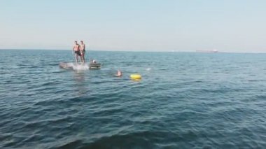 Neşeli gençler denize atlıyor. Havadan çekim