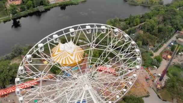 Parque de diversões à beira-mar. Vista da roda gigante e do parque aquático com um drone. Tiroteio de uma altura — Vídeo de Stock