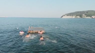 Neşeli gençler denize atlıyor. Havadan çekim