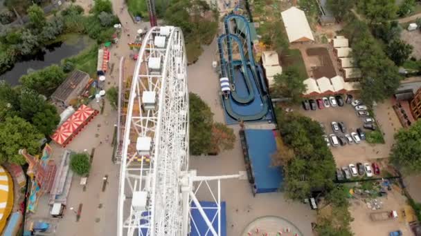 海辺の遊園地。観覧車とドローンでウォーターパークの眺め。高さからの撮影 — ストック動画