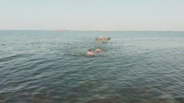 Erkekler denize dalın. Yazın deniz tatilleri. Havadan çekim