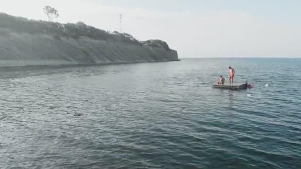 Adolescentes alegres están saltando al mar. Disparo aéreo — Vídeos de Stock