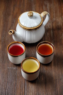 Koyu ahşap arka plan üzerinde çaydanlıklarda farklı çay. catering menüsü