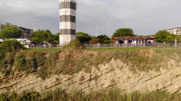 Repül át a világítótorony egy szikla a tengerparton, közel a tenger. Légifelvétel — Stock videók