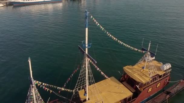 En el muelle se encuentra una vieja nave con mástiles. Disparo aéreo — Vídeo de stock