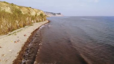 Deniz kenarında ki bir kayalıkta deniz fenerinin üzerinde uçmak. Havadan çekim