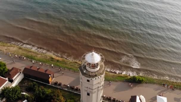 Repül át a világítótorony egy szikla a tengerparton, közel a tenger. Légifelvétel — Stock videók