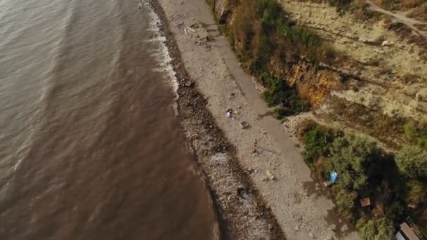 Volando sobre el faro en un acantilado de la costa cerca del mar. Disparo aéreo — Vídeo de stock