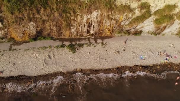 Flying over the lighthouse on a cliff of the coast near the sea. Aerial shot — Stock Video