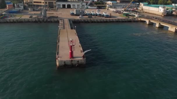 Red lighthouse at sea. Aerial shot — Stock Video