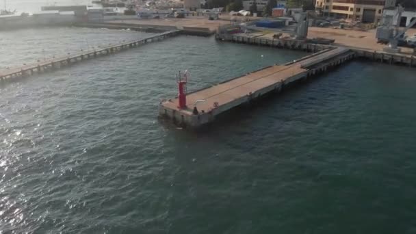 Red lighthouse at sea. Aerial shot — Stock Video