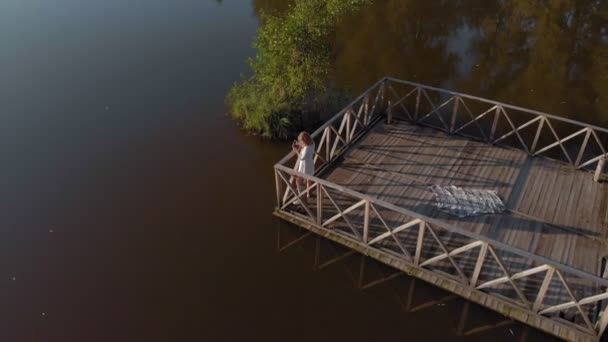 En ung kvinna använder en tablett vid älven. Aerial shot — Stockvideo