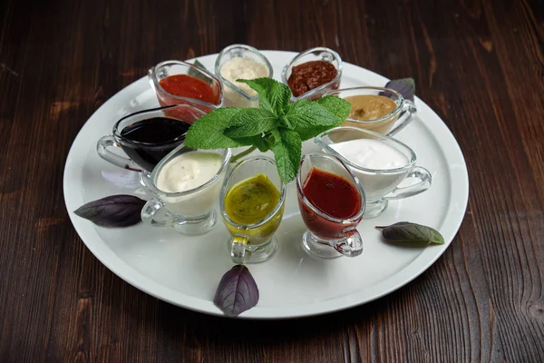 Salsas en cuencos sobre un fondo de madera oscura. menú para catering —  Fotos de Stock