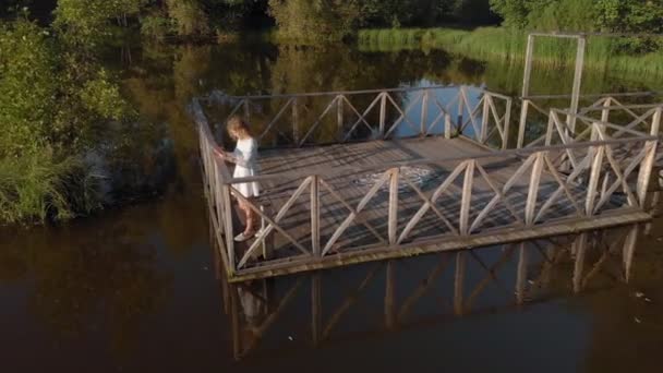 Молодая женщина пользуется табличкой у реки. Воздушный удар — стоковое видео