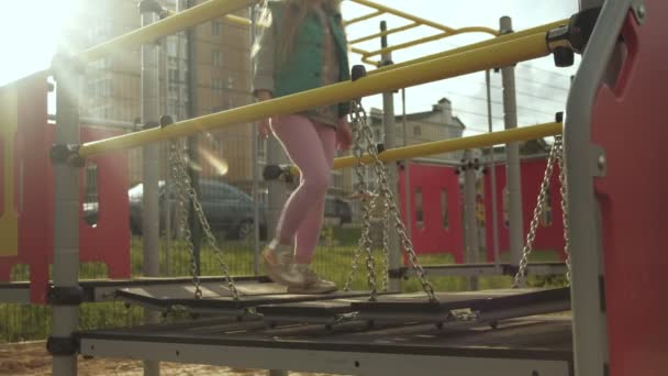 Una niña juega en un campo de deportes al aire libre. Puesta de sol — Vídeos de Stock