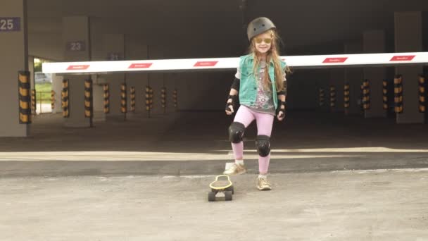 Uma menina cavalga em um skate amarelo — Vídeo de Stock