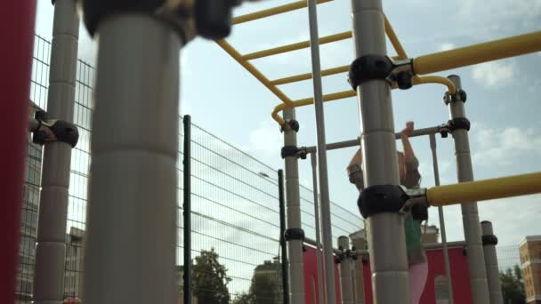 Una niña juega en un campo de deportes al aire libre. Puesta de sol — Vídeos de Stock