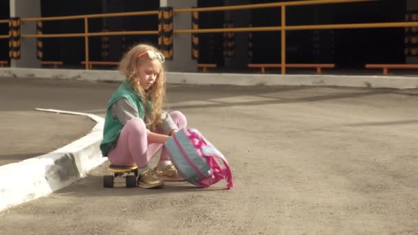 Little girl dresses protection: helmet, knee pads and elbow pads. Sunset — Stock Video