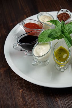 koyu ahşap arka plan üzerinde kase lerde soslar. catering için menü