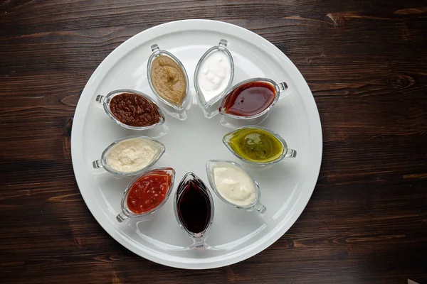 Salsas en cuencos sobre un fondo de madera oscura. menú para catering —  Fotos de Stock