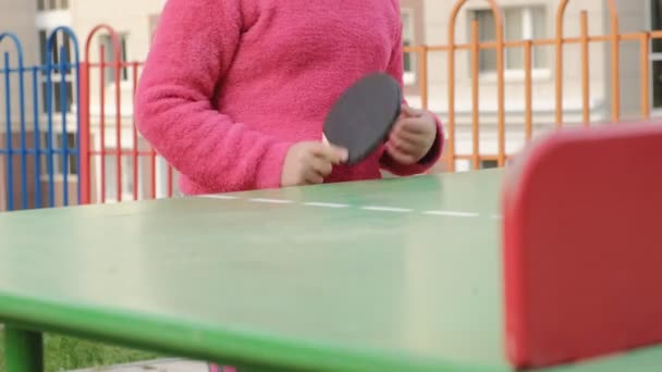 Menina adolescente jogando tênis de mesa ao ar livre — Vídeo de Stock