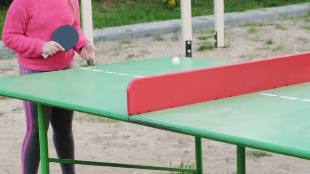 Menina adolescente jogando tênis de mesa ao ar livre — Vídeo de Stock