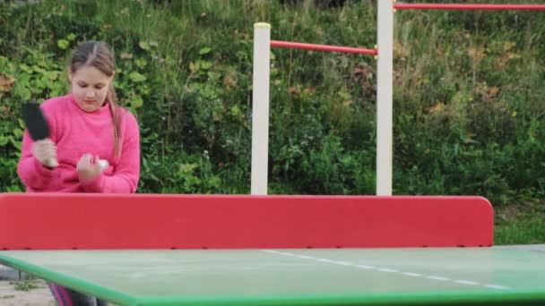 Adolescente chica jugando al tenis de mesa al aire libre — Vídeo de stock