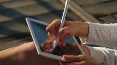 Kadın dışarıda bilgisayar tableti kullanıyor..
