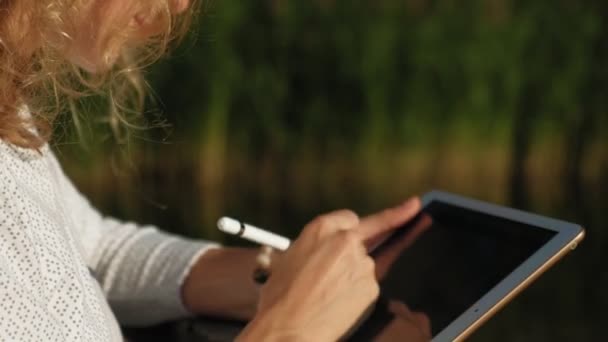 Η γυναίκα χρησιμοποιεί ένα tablet υπολογιστή σε εξωτερικούς χώρους. — Αρχείο Βίντεο