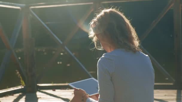 Mujer está utilizando una tableta de ordenador al aire libre . — Vídeo de stock