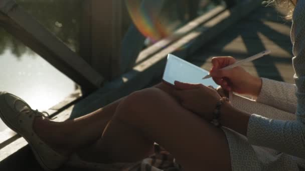 Mulher está usando um tablet de computador ao ar livre . — Vídeo de Stock