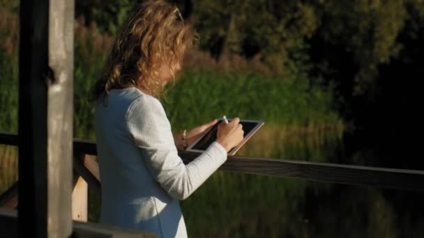 Femme utilise une tablette d'ordinateur à l'extérieur . — Video