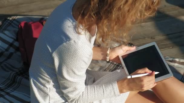 Mujer está utilizando una tableta de ordenador al aire libre . — Vídeo de stock