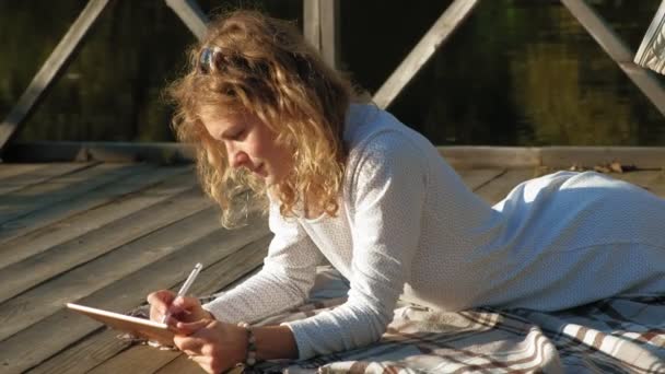 Mujer está utilizando una tableta de ordenador al aire libre . — Vídeos de Stock