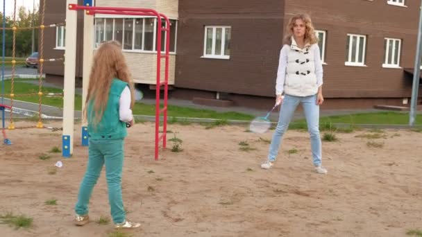 Mamá y su hija juegan al bádminton al aire libre — Vídeo de stock