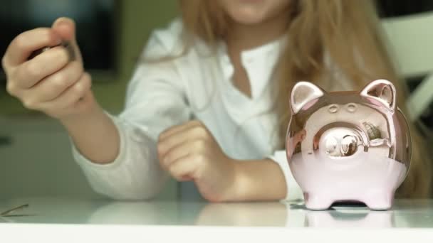 Meisje kleuter zet geld in een Piggy Bank Pink Pig — Stockvideo