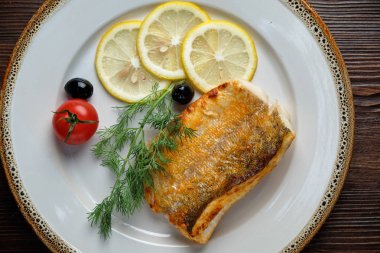 Beyaz tabakta beyaz pişmiş balık. catering menüsü