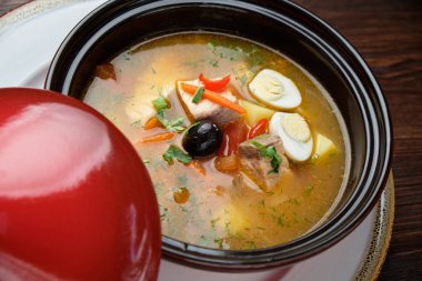 Kırmızı kapaklı bir tencerede balık çorbası. catering menüsü