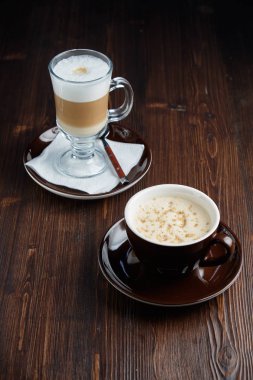 Kahverengi ahşap arka plan üzerinde Kapuçino. Menü