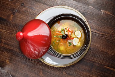 Kırmızı kapaklı bir tencerede balık çorbası. catering menüsü