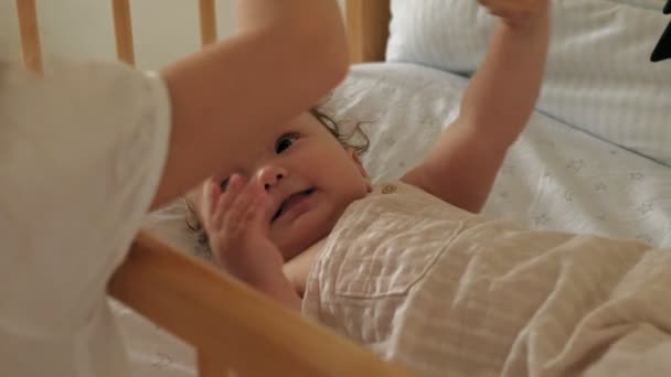 Meisje Preschool meisje staat op de wieg met een kind, kalmeert haar. Zorgen voor een klein zusje — Stockvideo