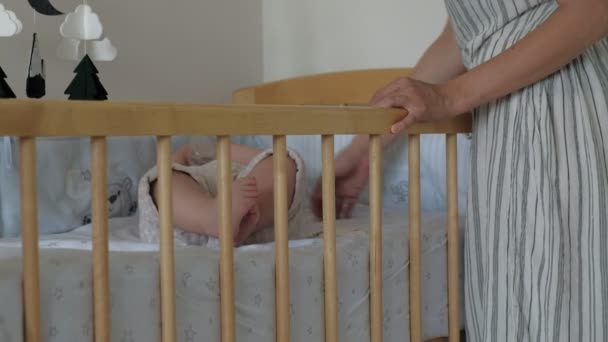 Мама кормит ребенка из бутиков в кроватке — стоковое видео