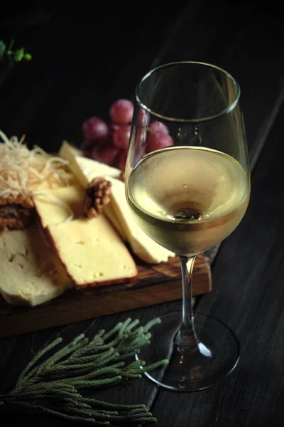Szklanka zimnego białego wina z serową przekąską na drewnie. menu cateringowe — Zdjęcie stockowe