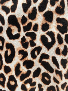 Bej arka planda koyu siyah ve kahverengi lekeli leopar desenli kumaş. Klasik hayvan deseni, moda ve vahşi tekstil tasarımı moda, giysi, dekor, arka plan ve el sanatları için mükemmel..