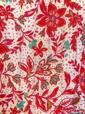 Kırmızı ve pembe çiçekli çiçek deseni, yeşil yapraklar ve beyaz arka planda dekoratif detaylar. Renkli tekstil tasarımı moda, ev dekorasyonu, el sanatları ve modern modeller için idealdir..