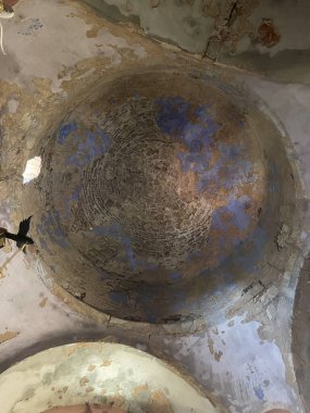 Derisi soyulmuş alçı ve solmuş fresk kalıntılarıyla eski kilise tavanı. Eski Bizans mimari detayları eski dokuları, çatlak boyaları ve kutsal bir yerin içindeki tarihi atmosferi gösteriyor..