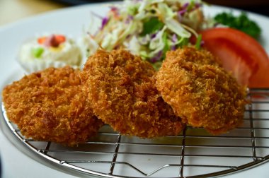 Salata sebzeli tonkatsu. Kızarmış domuz eti ve çiğ sebze. Japon mutfağı. Yiyecek ve içecek konsepti. Gıda arkaplanı.