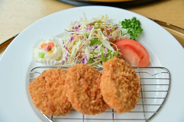 Salata sebzeli tonkatsu. Kızarmış domuz eti ve çiğ sebze. Japon mutfağı. Yiyecek ve içecek konsepti. Gıda arkaplanı.