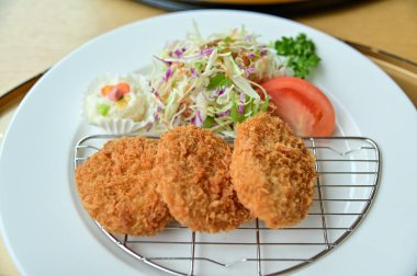 Salata sebzeli tonkatsu. Kızarmış domuz eti ve çiğ sebze. Japon mutfağı. Yiyecek ve içecek konsepti. Gıda arkaplanı.