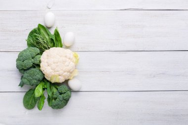 Karnabahar, brokoli, ıspanak ve tavuk yumurtaları beyaz ahşap arka planda. Arkaplan menüsü yemekleri. Üst görünüm, alanı kopyala